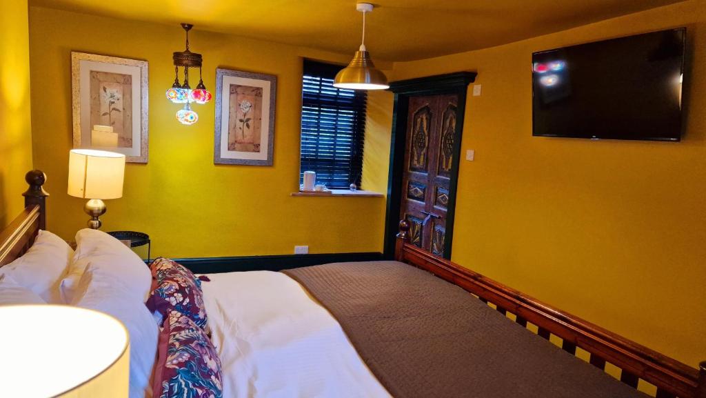 The Thai Room — bedroom with golden walls, Turkish mosaic lamps, and ornate carved door