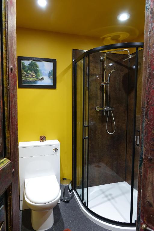 The Thai Room — en-suite bathroom with yellow walls, walk-in shower, and Thai painting