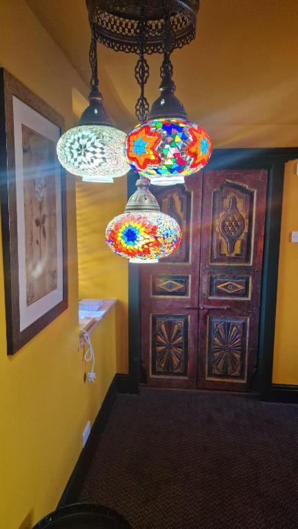 The Thai Room — hallway entrance with Turkish mosaic pendant lamps and carved wooden door
