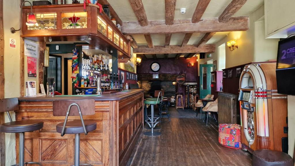 Y Gwydyr Hotel bar interior with wooden beams, jukebox, and bar stools