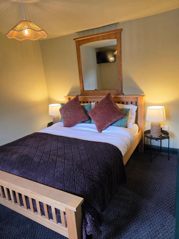 The Classic Room — bedroom with wooden bed frame, purple throw, and mirror